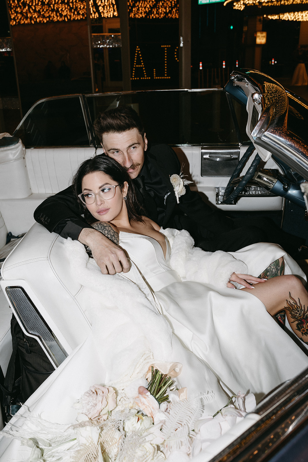 Bride in White Fur Coat sitting with Groom in Classic Car in Downtown Las Vegas 