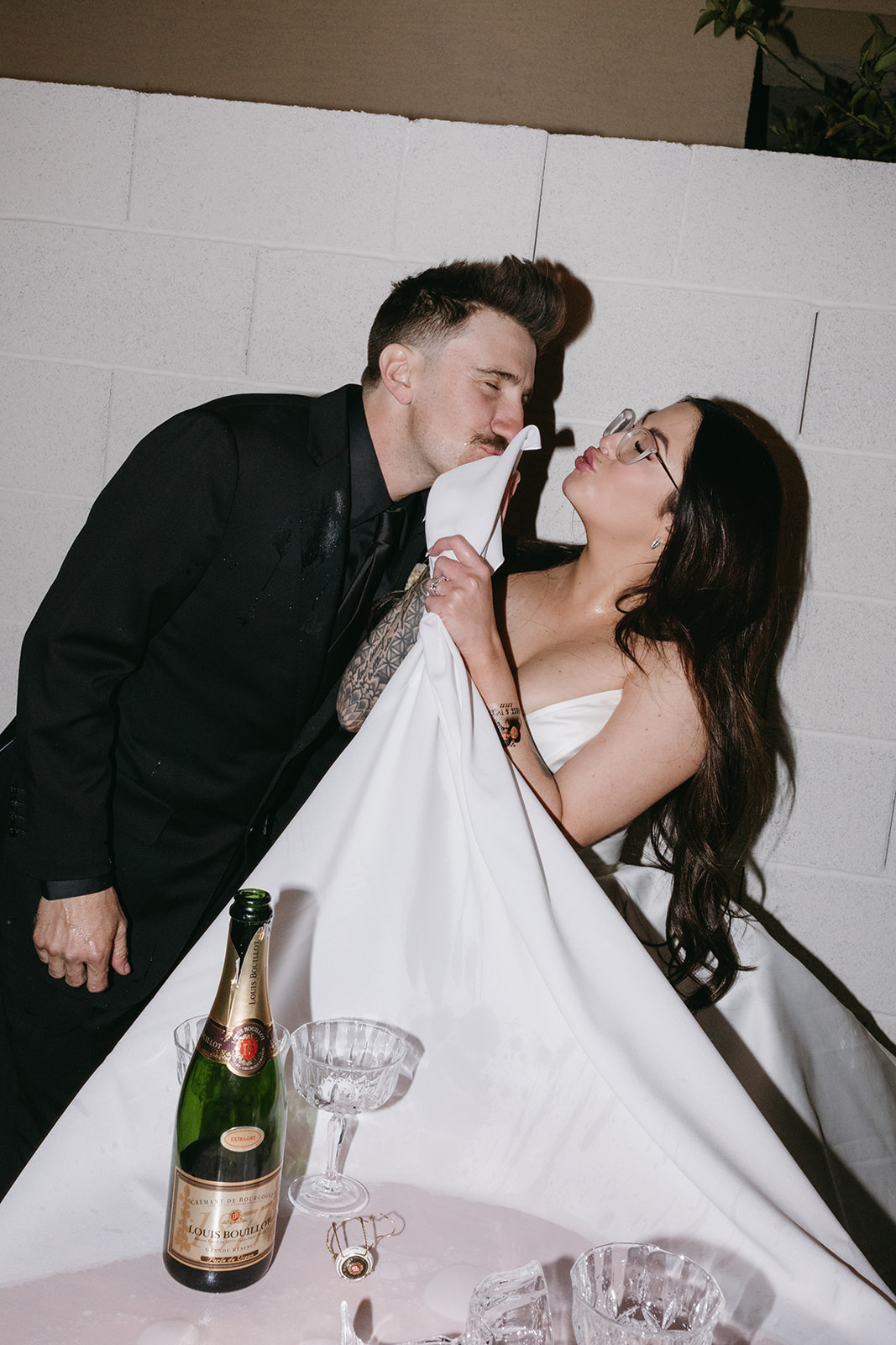Bride using Table Cloth on Grooms Face during Fun Reception following Little White Wedding Chapel Modern Vegas Wedding Ceremony 