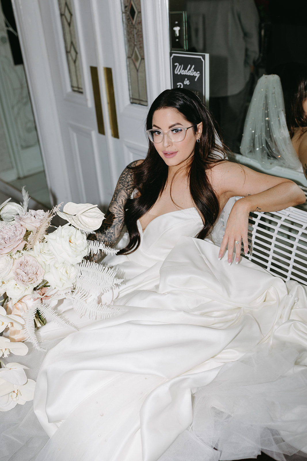 Bride Sitting on Bench with Modern Bouquet wearing Clear Glasses for Vegas Wedding 