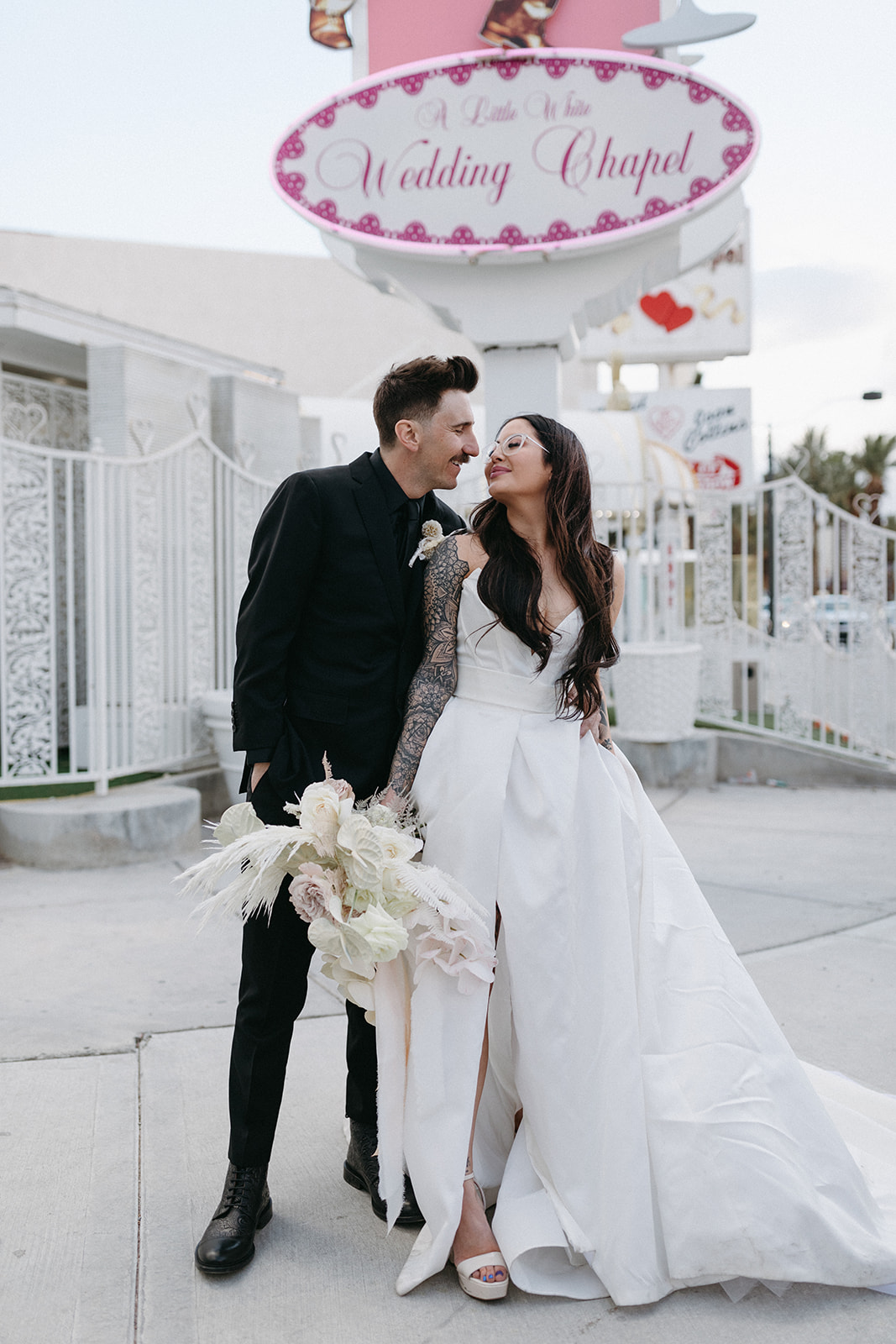 Couple in Front of Pink Sign during Little White Wedding Chapel Modern Vegas Wedding