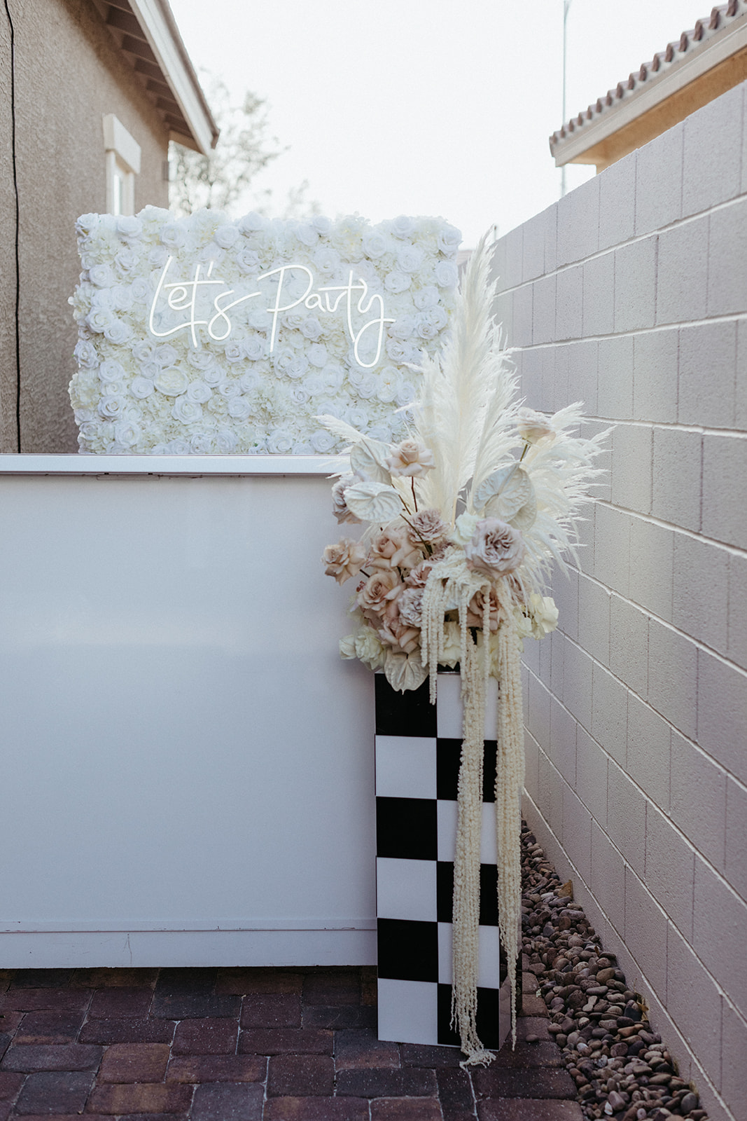 Monochromatic and Modern Reception Florals with Checkered Black and White Stand and Flower Wall with Neon Let's Party Sign 