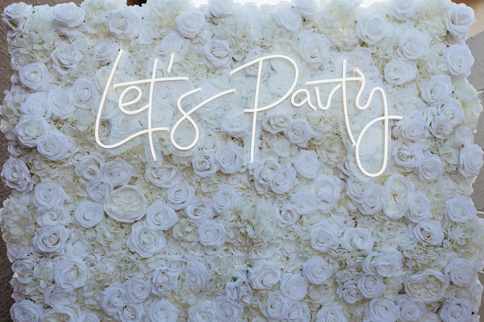 White Flower Wall with Let's Party Neon Sign 