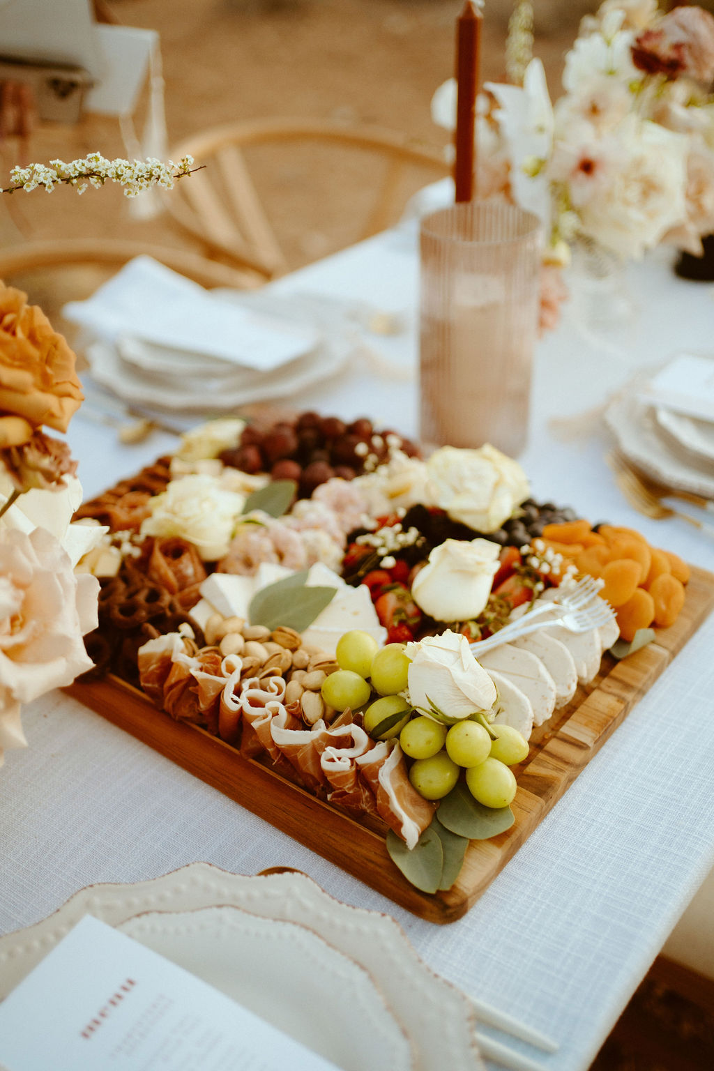 charcuterie board in front of the bride and grooms plate at the sweetheart table.