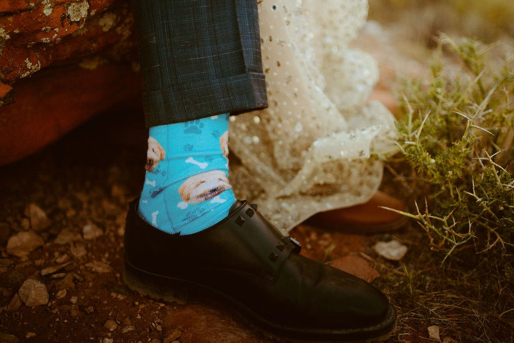 Micro-Wedding Reception at Ash Springs. Groom rocking bright blue socks with their dogs face printed all over with bones and dog prints. 