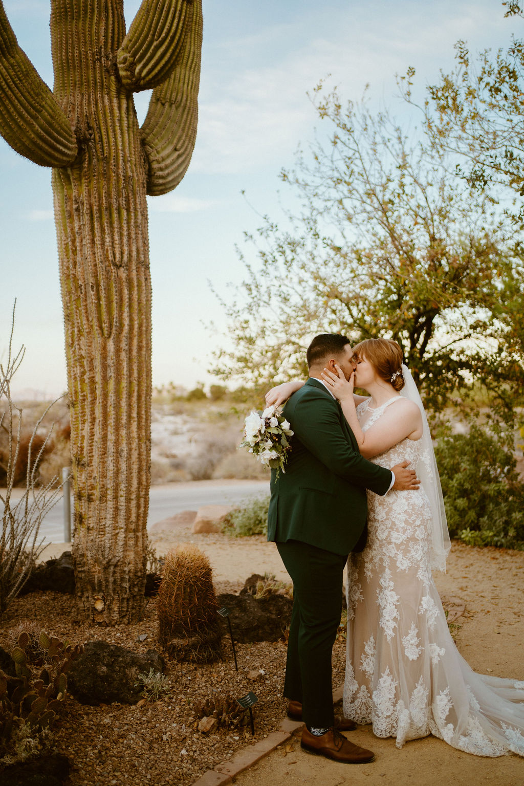 Bride and groom kissing near cactus for Springs Preserve Greenery Elopement