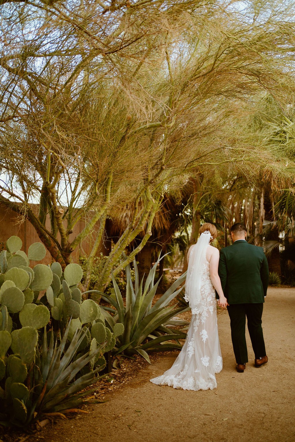Bride and groom walking in cactus garden for Springs Preserve Greenery Elopement