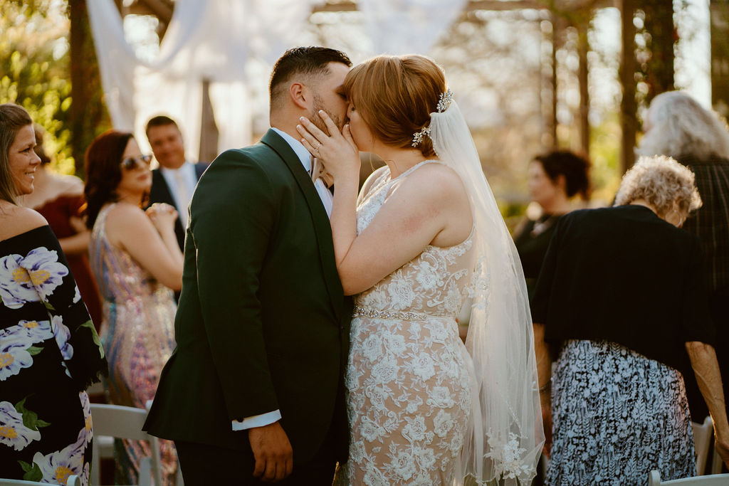 Bride and Groom kissing at the end of the aisle after getting married 