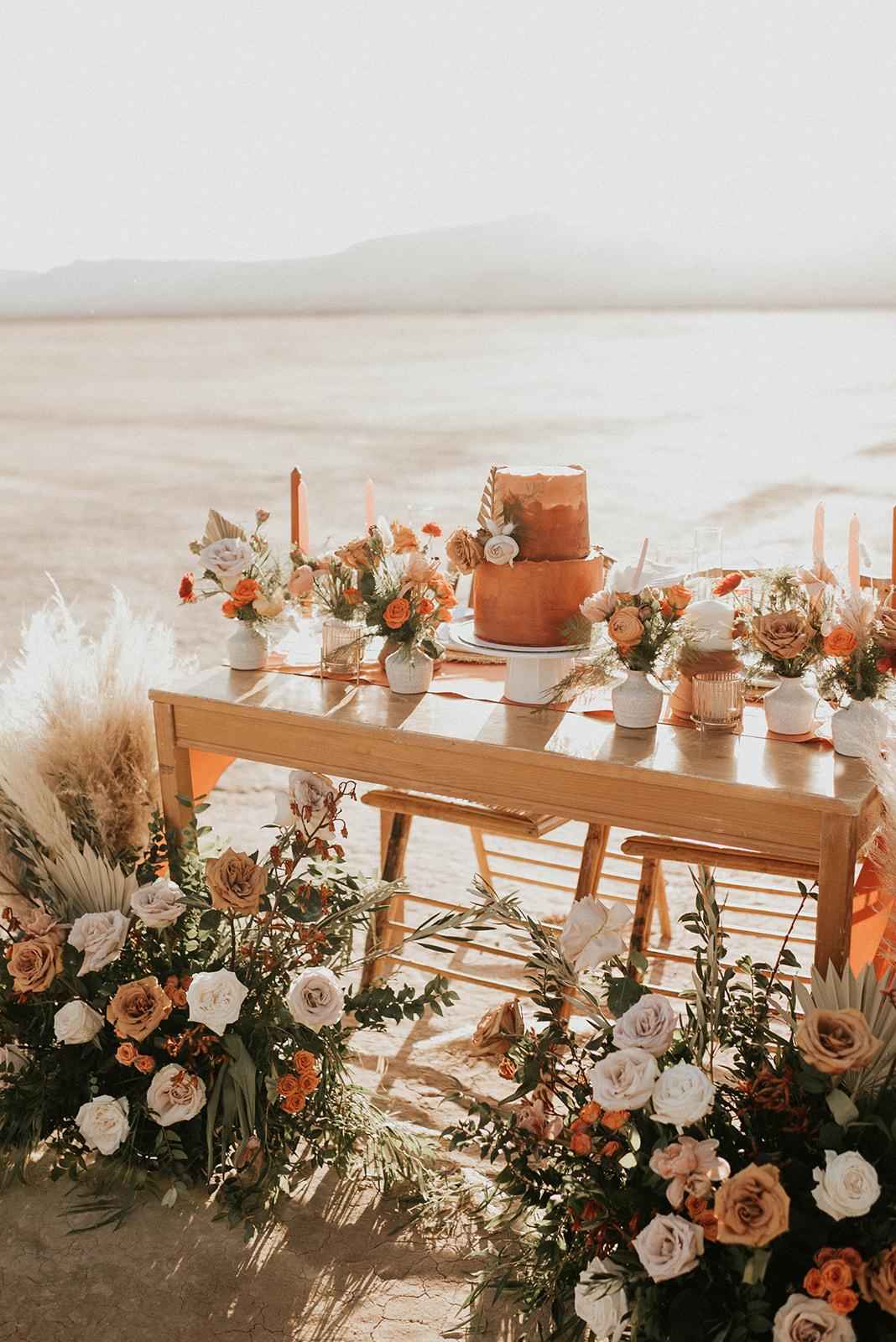 Sweetheart table decorated with boho styled florals and cake. 