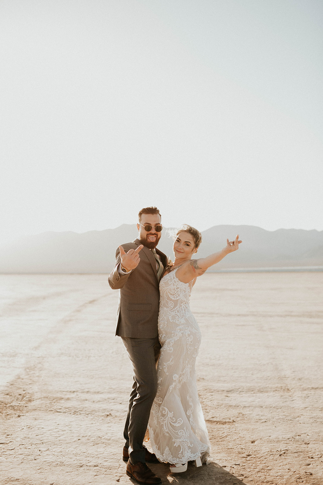Bride and groom flipping off the camera in the Las Vegas Desert. 