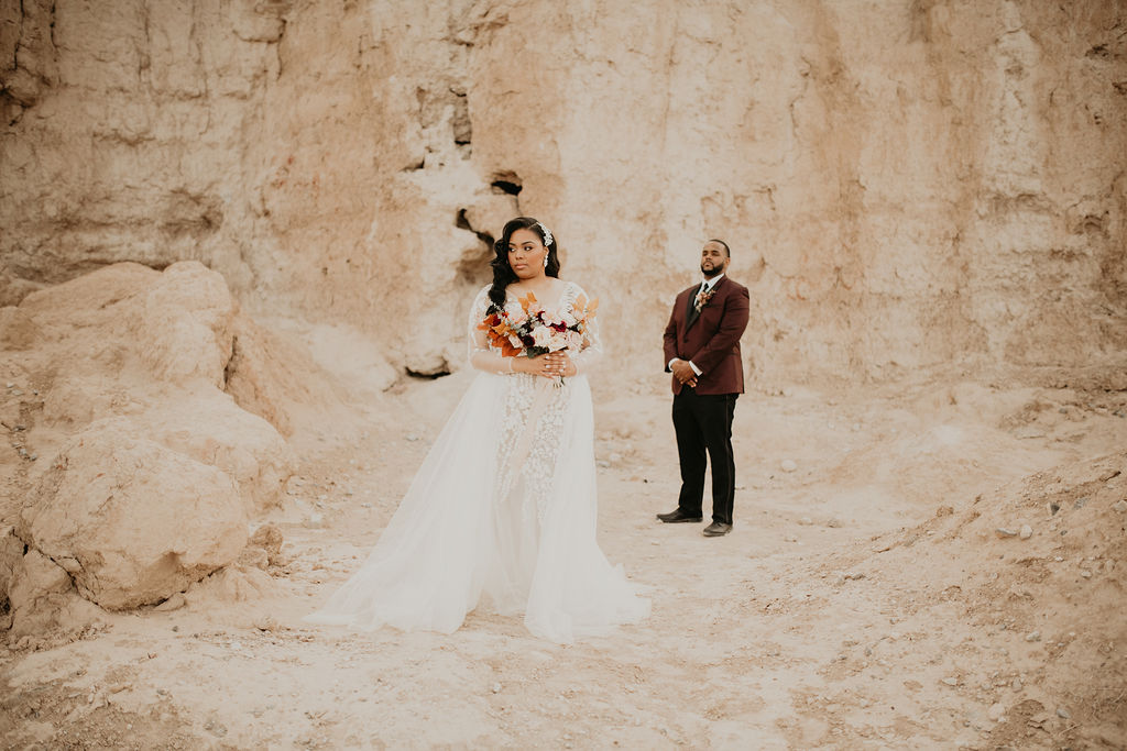 Fossil Beds Sunset Elopement stunning bride in front of the groom standing in the middle of the breathtaking fossil beds.