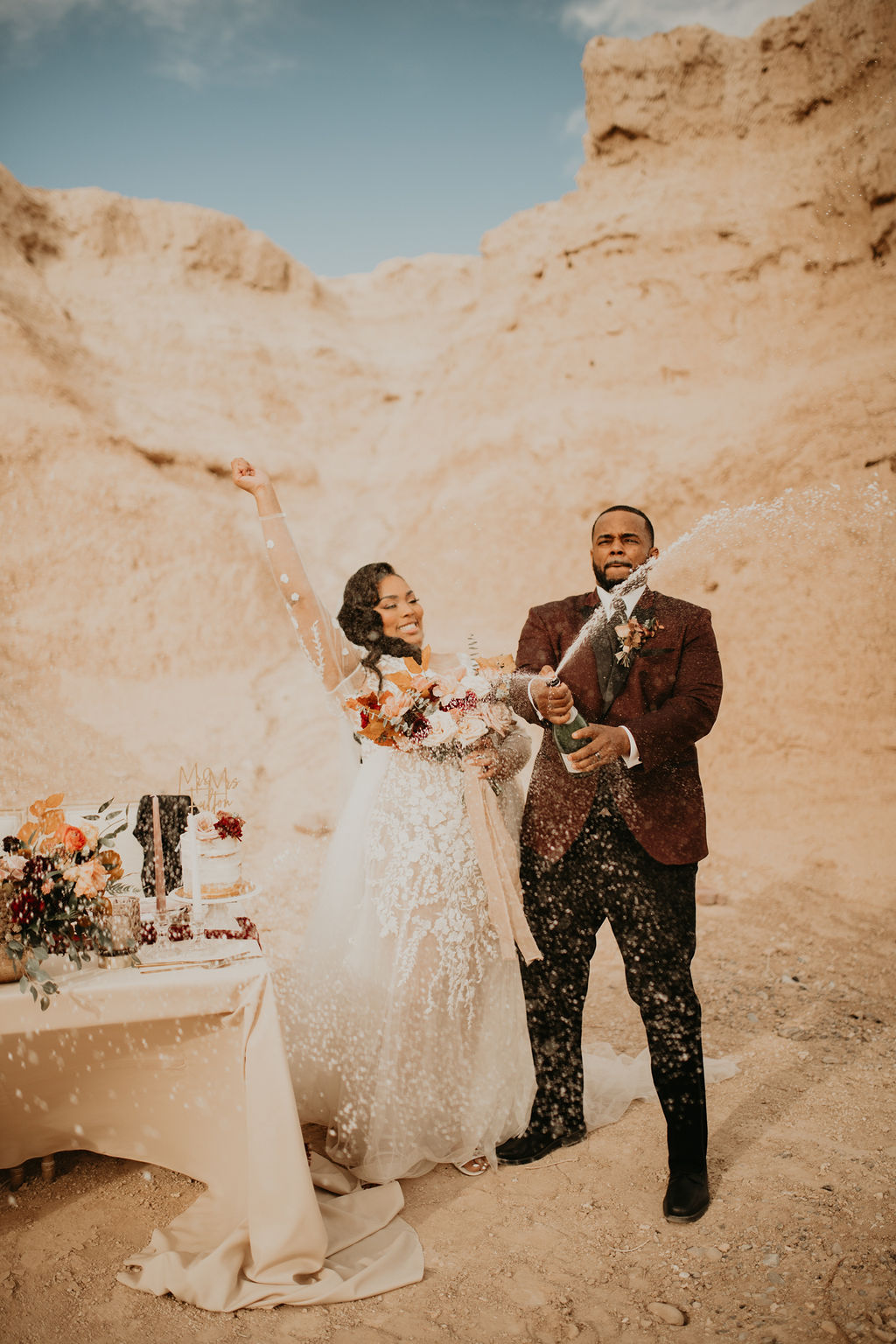 Fossil Beds Sunset Elopement happy newlyweds cheering and spraying champagne in fossil beds 