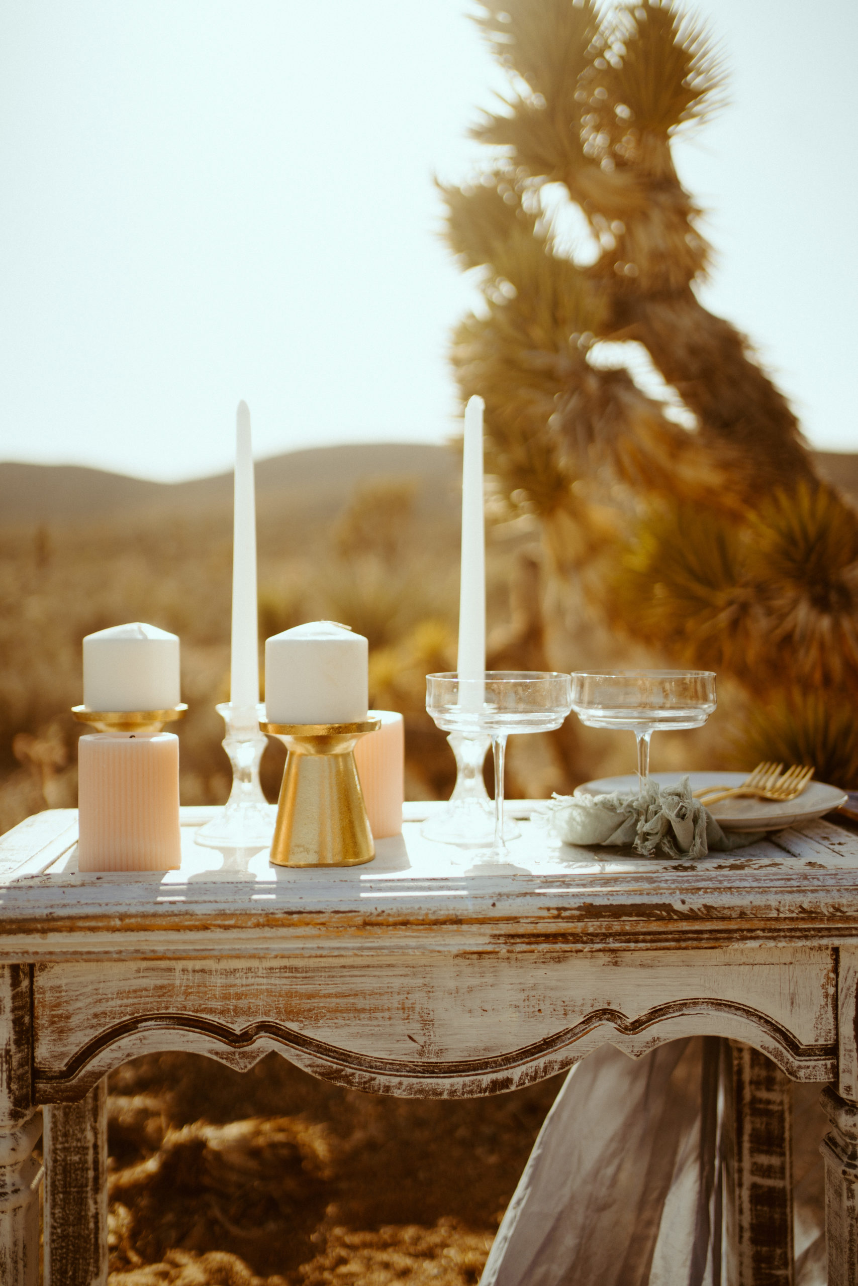 Gold candle holders on rustic table with pink and white candles 