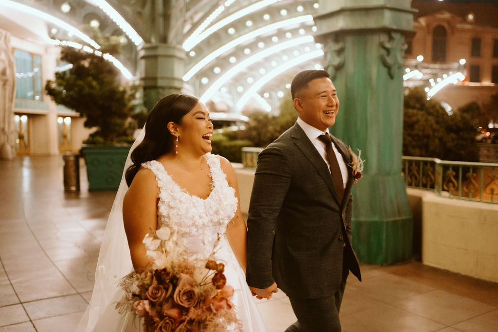 Bride and Groom laughing while walking through Las Vegas Strip before Elopement Ceremony at Red Rock 