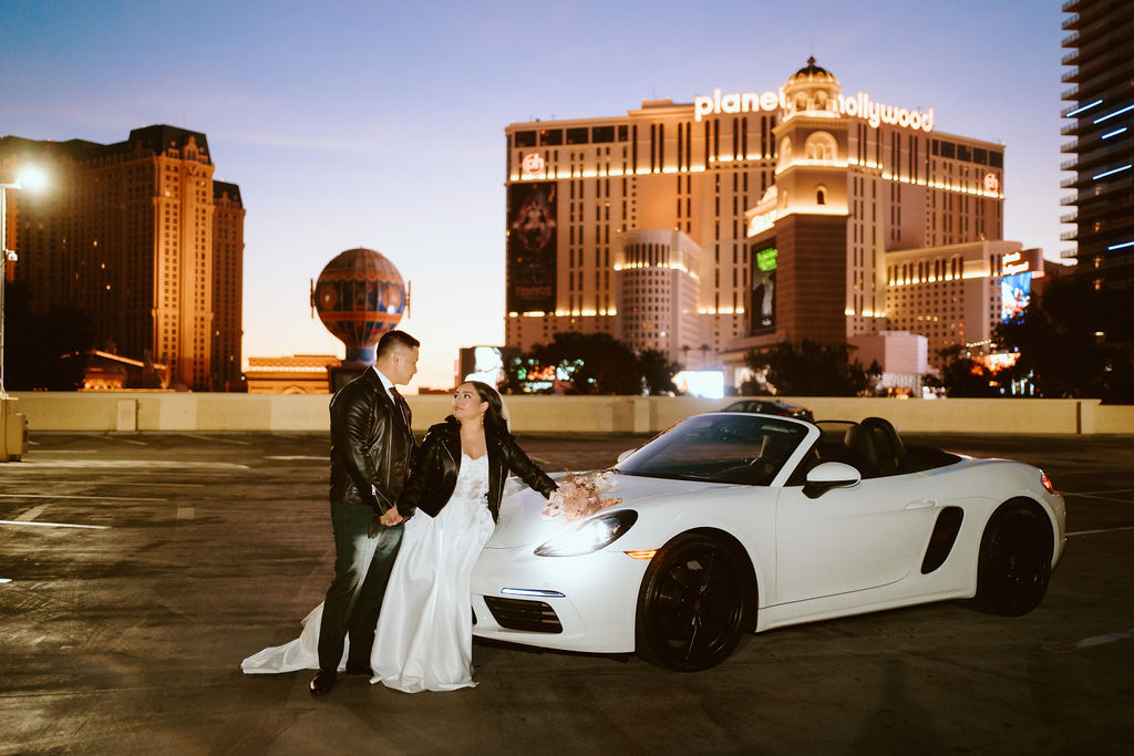 Bride and Groom with Convertible on top level of parking garage at sunrise about to leave for Desert Elopement 