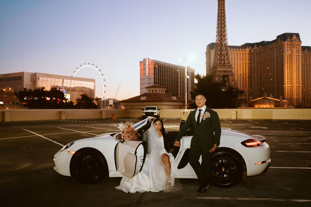Bride and Groom with Convertible on top level of parking garage at sunrise with High Roller and Paris Hotel in the Background  