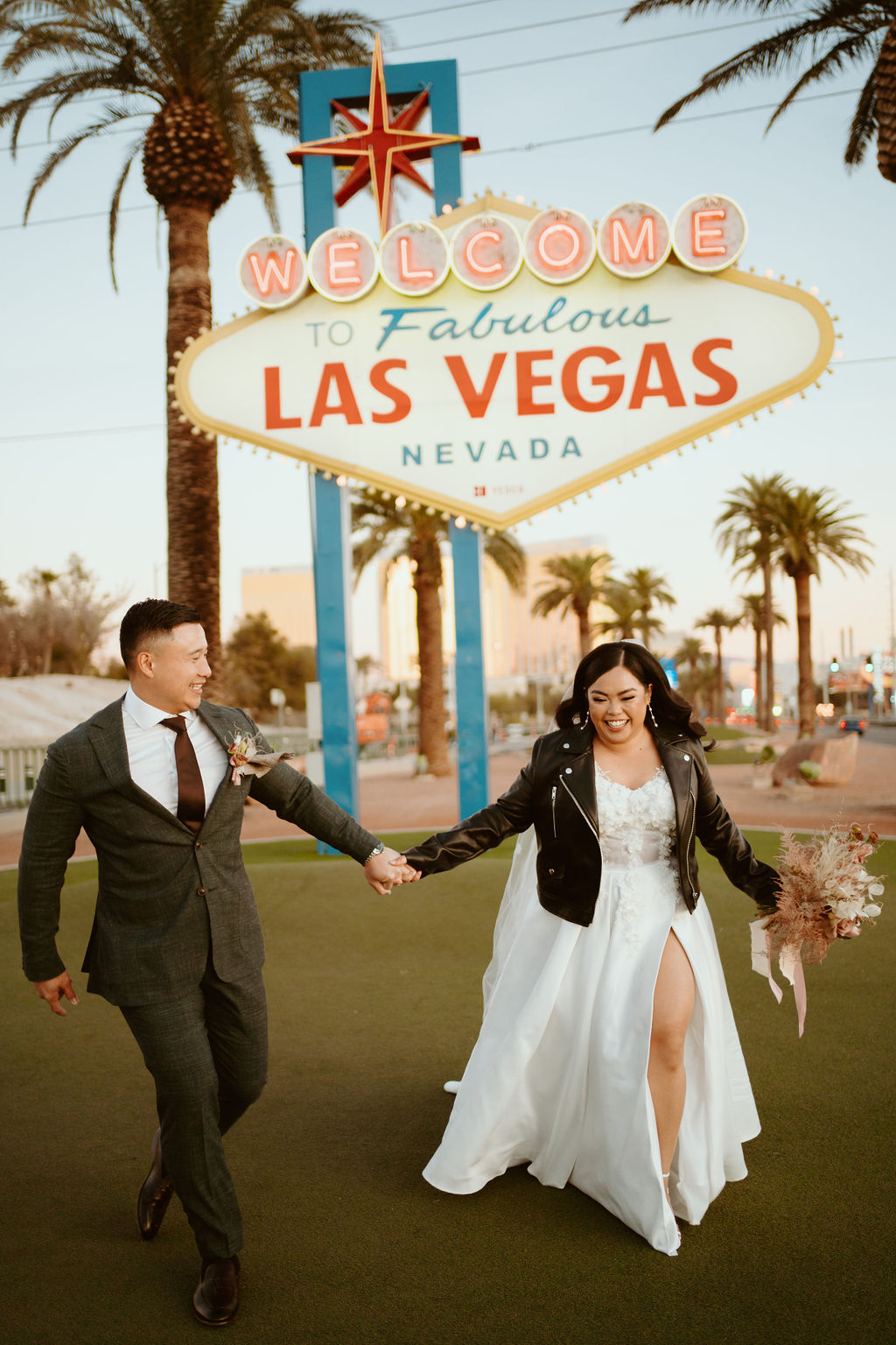 Bride and Groom walking and laughing in front of Welcome to Fabulous Las Vegas Nevada Sign during Las Vegas Highlights & Desert Elopement