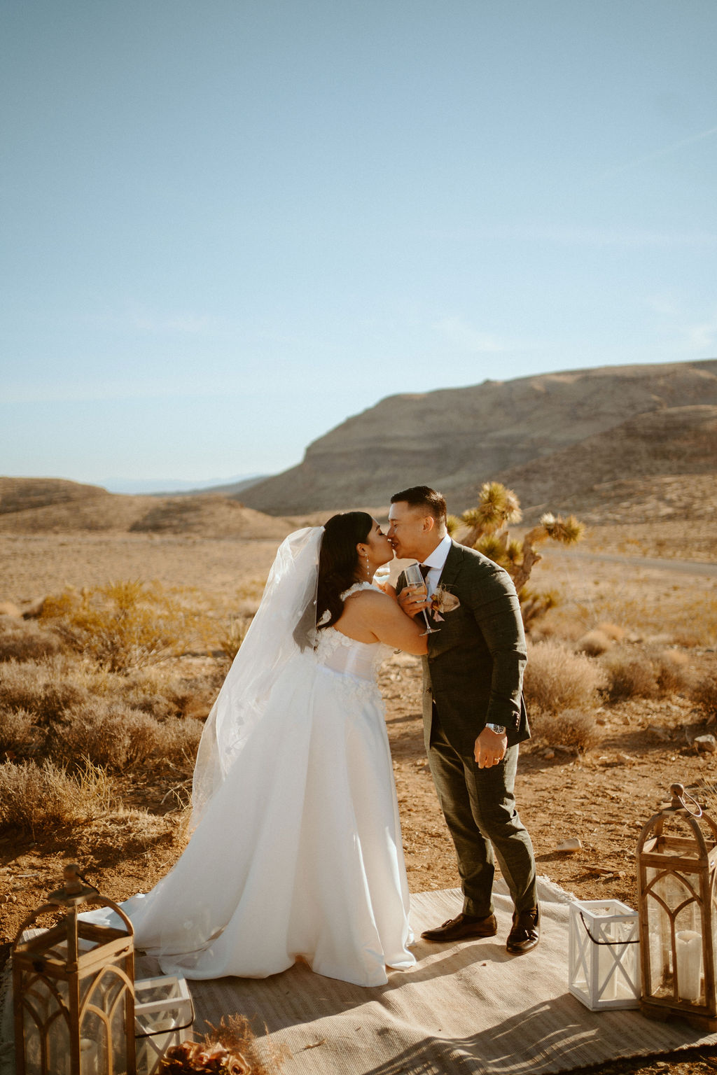 Bride and Groom Kissing with Champagne Glasses during Las Vegas Highlights & Desert Elopement