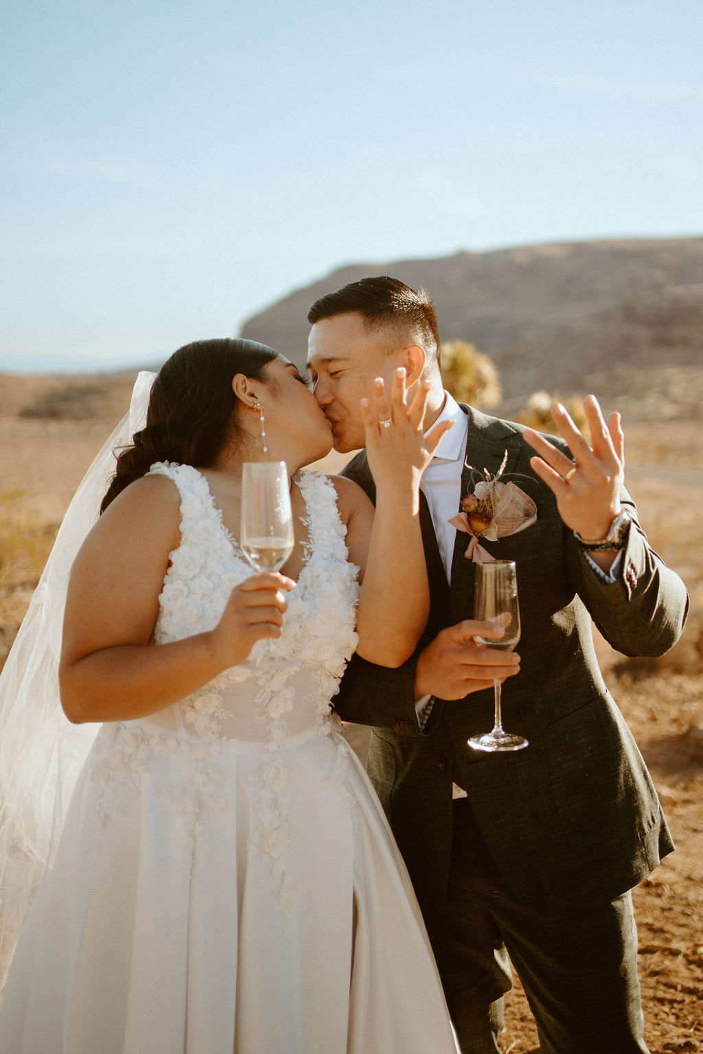 Newlyweds showing rings and kissing during Las Vegas Highlights & Desert Elopement