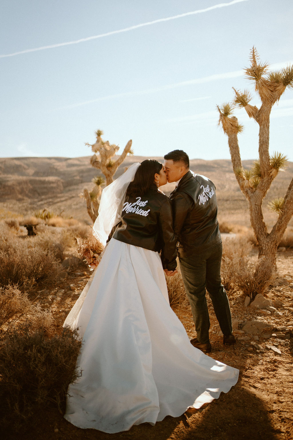Newlyweds both wearing Just Married Custom Black Leather Jackets in Las Vegas Desert 