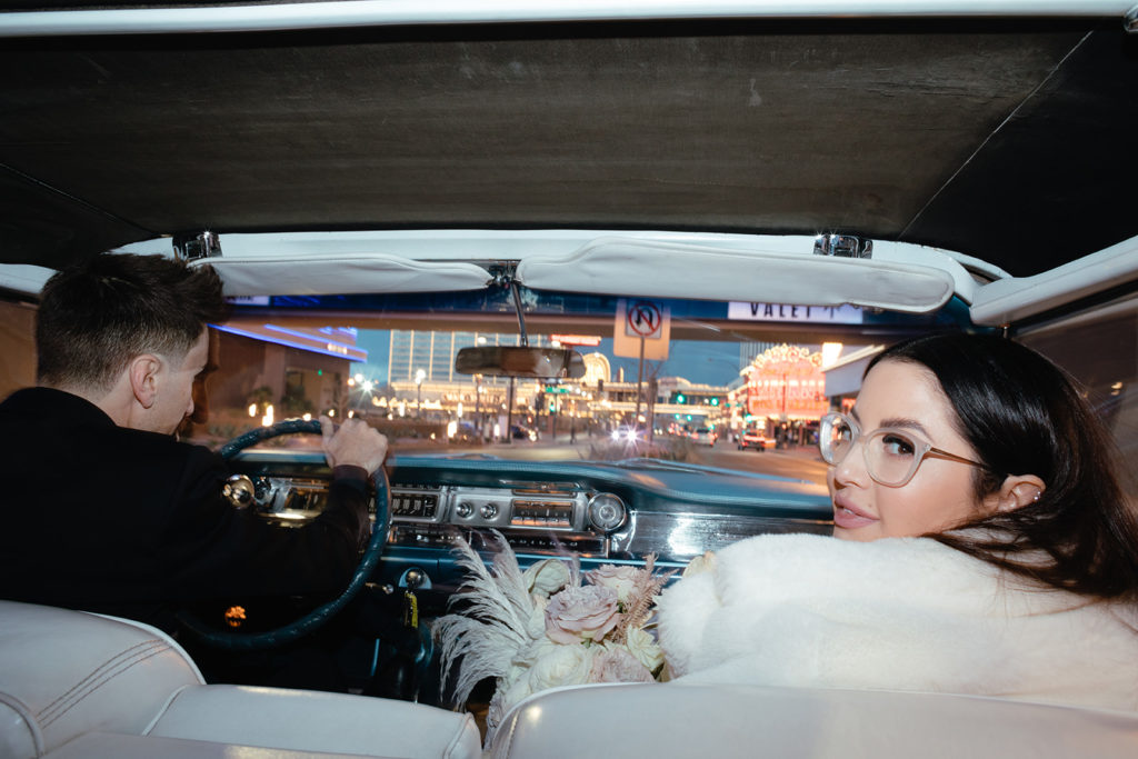 bride and groom in classic car driving through Las Vegas