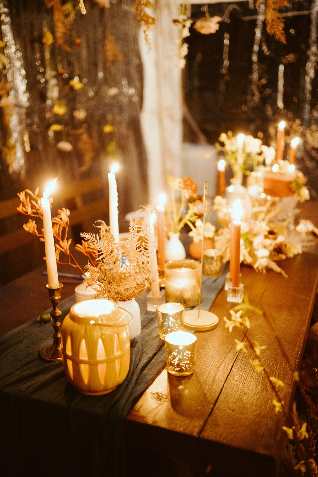 Close up photo of the sweetheart table with the taper candles and votives all light