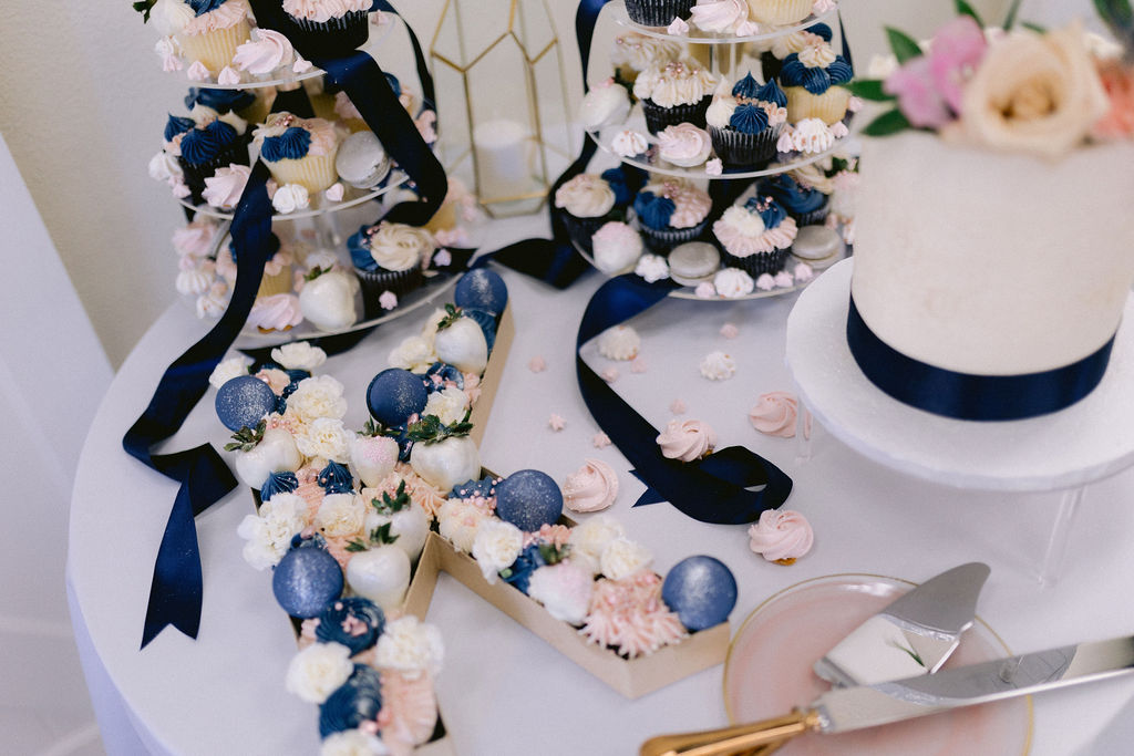 Close up of a K decorated in blush pink and navy blue sweet. 