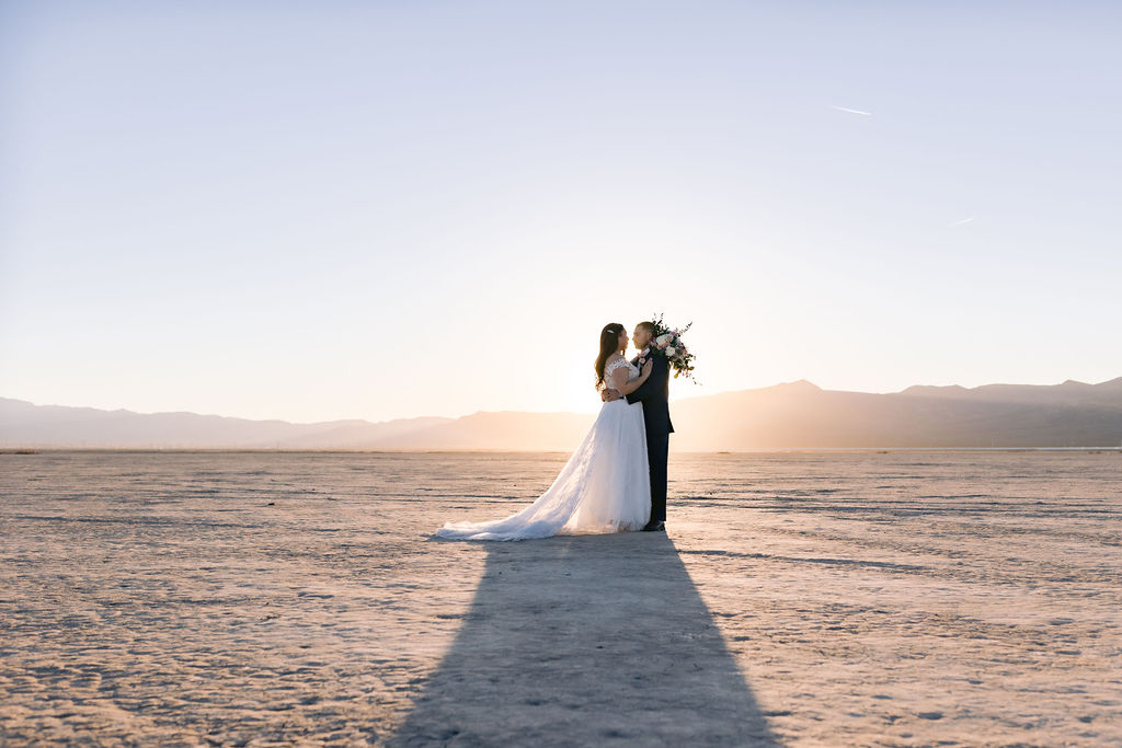 Navy Blue & Blush Pink Micro-Wedding a beautiful sunset shot in the desert with the silhouette mountains and the sun perfectly behind the couple. 