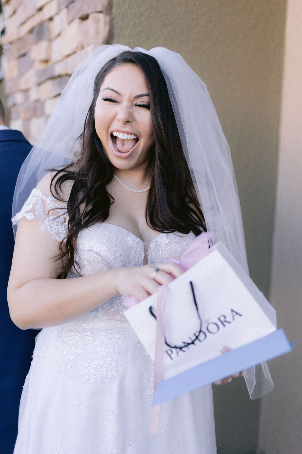 Bride laughing as she opens a gift from the groom. 