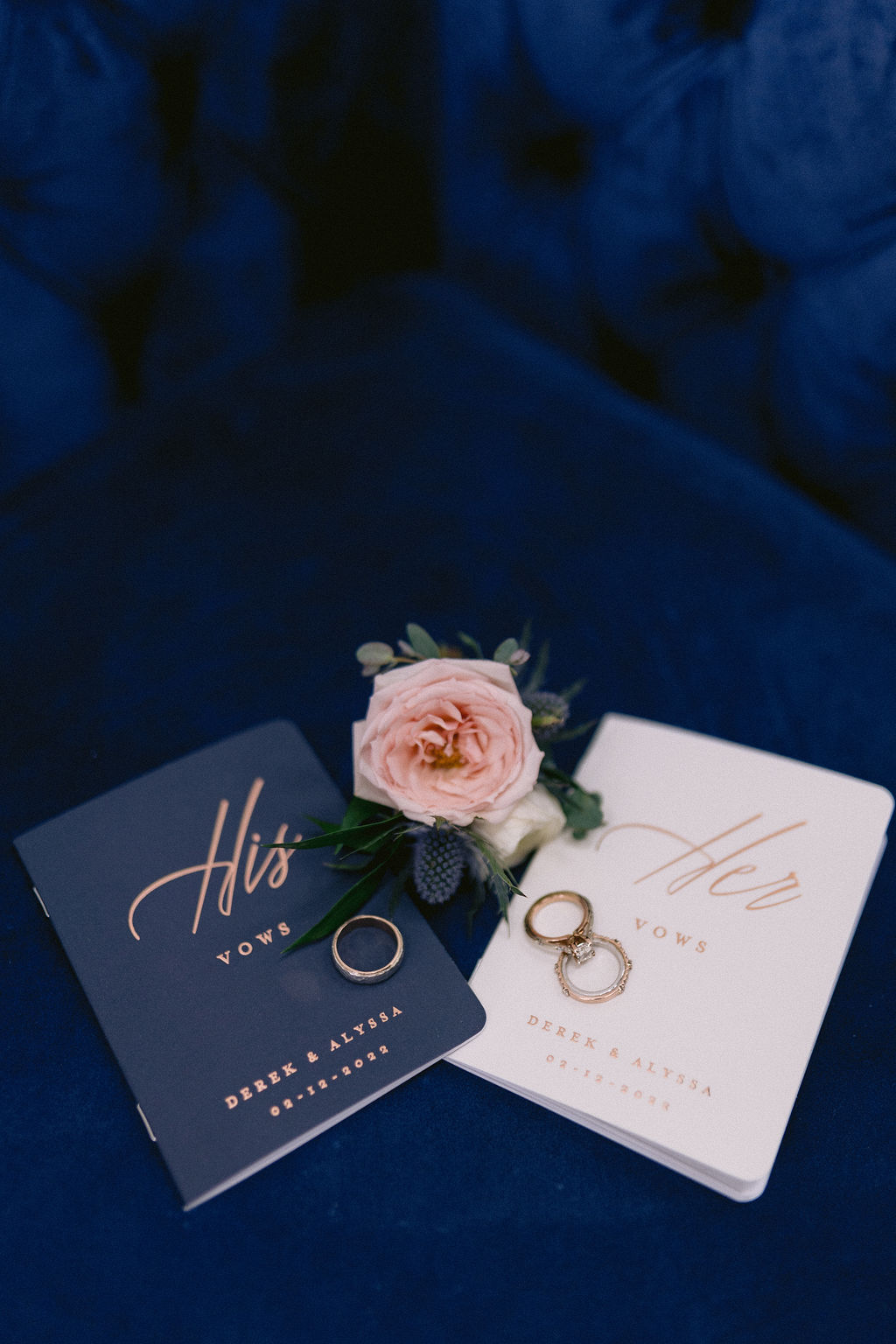 Navy Blue & Blush Pink Micro-Wedding bride and grooms vow books with their rings laid on top. 