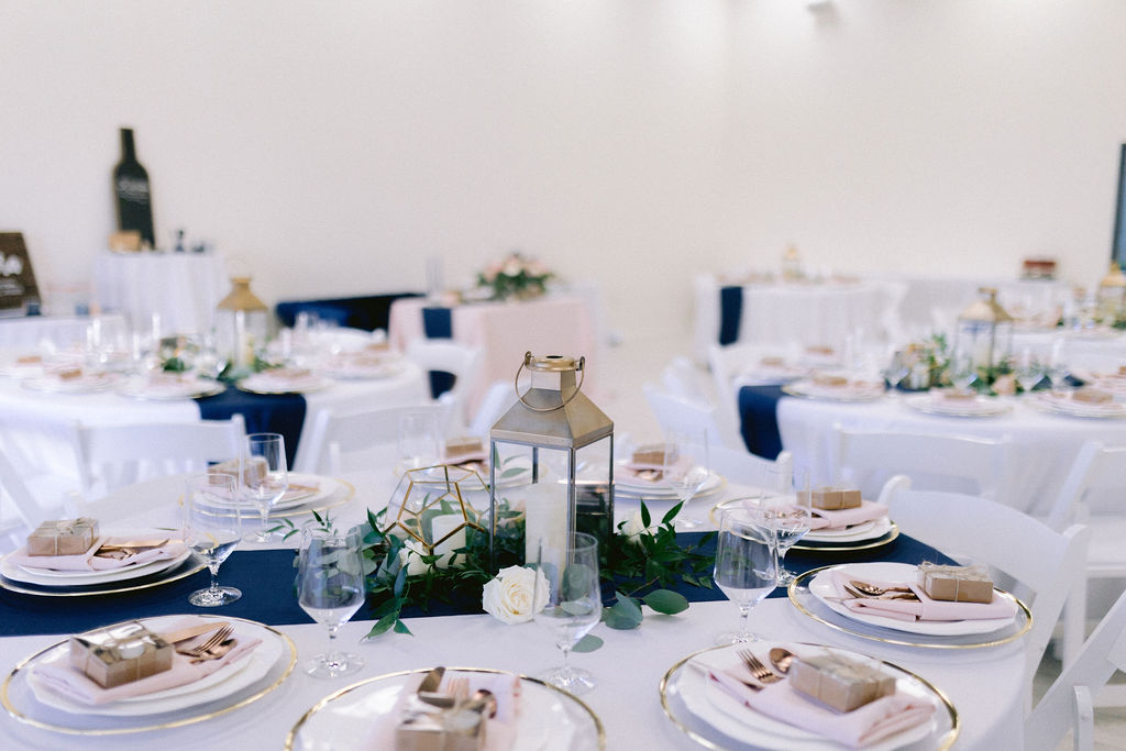 Reception tables decorated with navy blue and blush pink decor. 