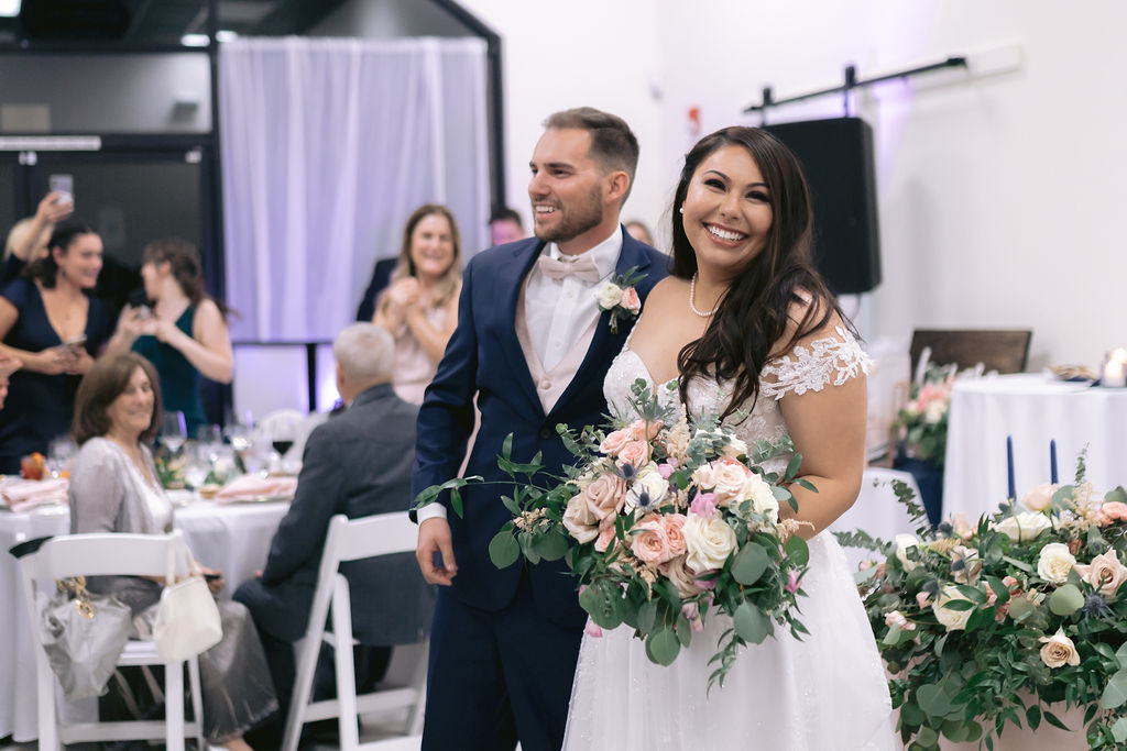Navy Blue & Blush Pink Micro-Wedding bride and groom walk into their reception 
