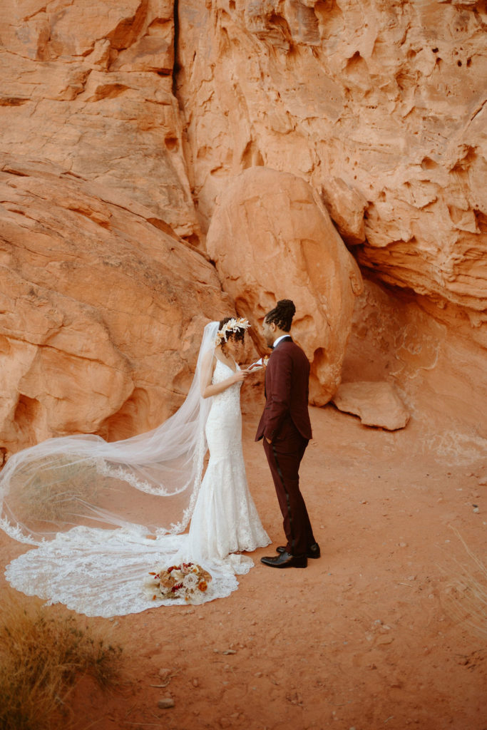 Romantic Mauve & Desert Hues Elopement bride reading her vows to the groom. Her bouquet laying on her wedding dress. 