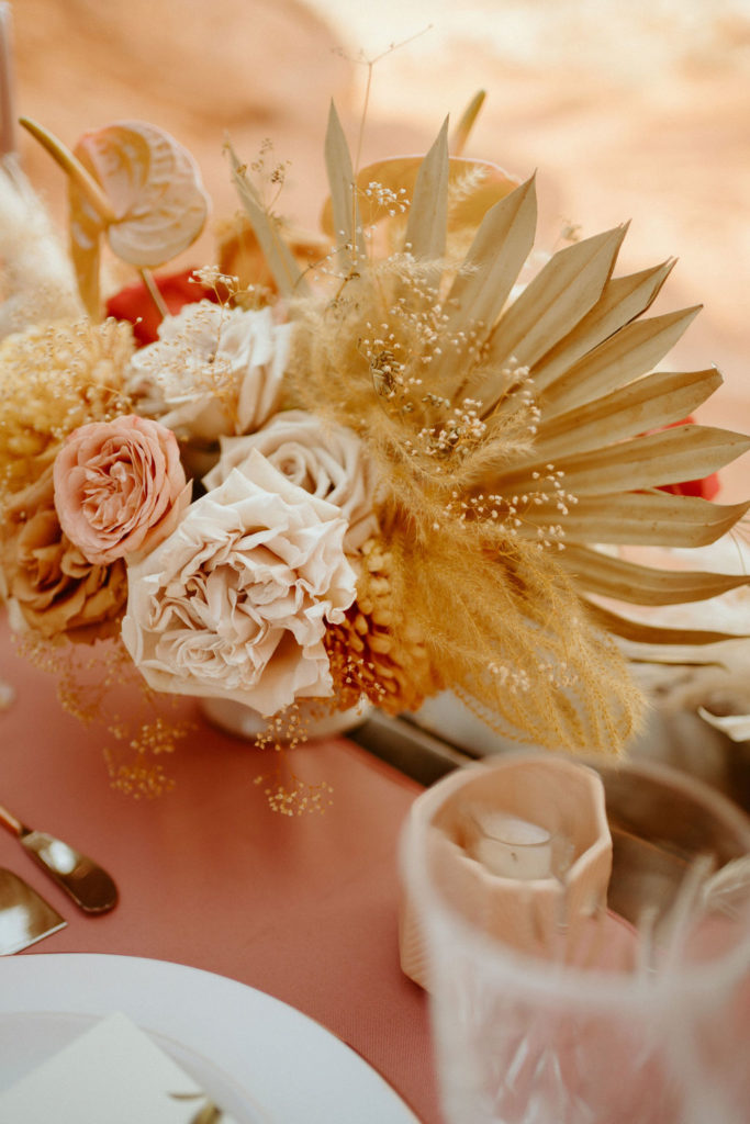 Romantic Mauve & Desert Hues Elopement close up of the table center piece. With roses, pampas, and leaf fan. 