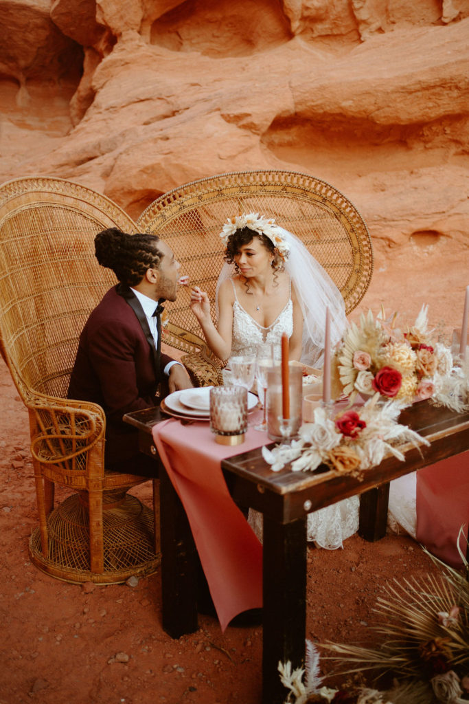 Romantic Mauve & Desert Hues Elopement bride feeding  groom a piece of wedding cake. 