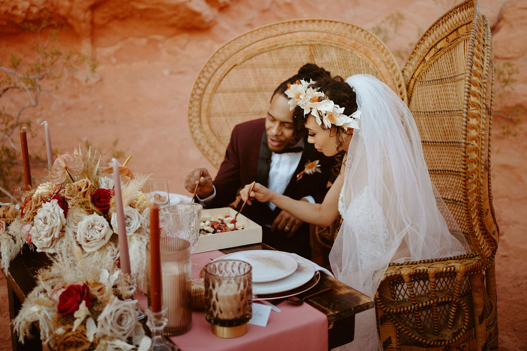 Romantic Mauve & Desert Hues Elopement bride and groom enjoying a delicious charcuterie box. 