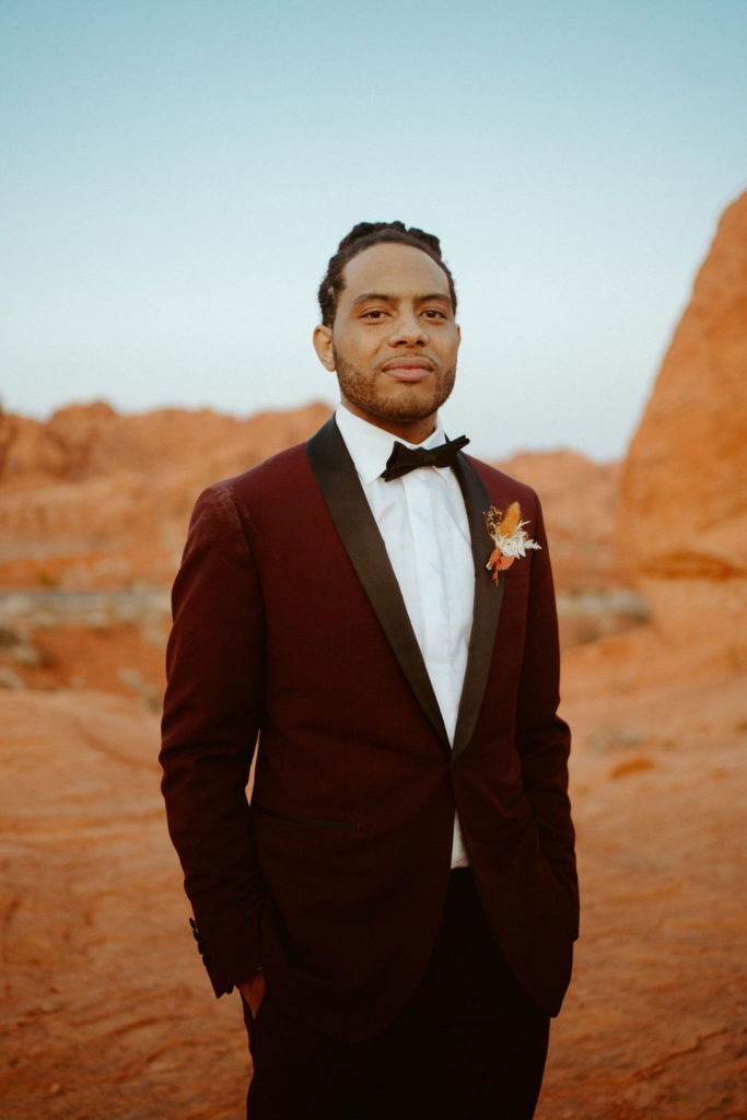 Close up of groom in his deep maroon colored suit and bowtie. 