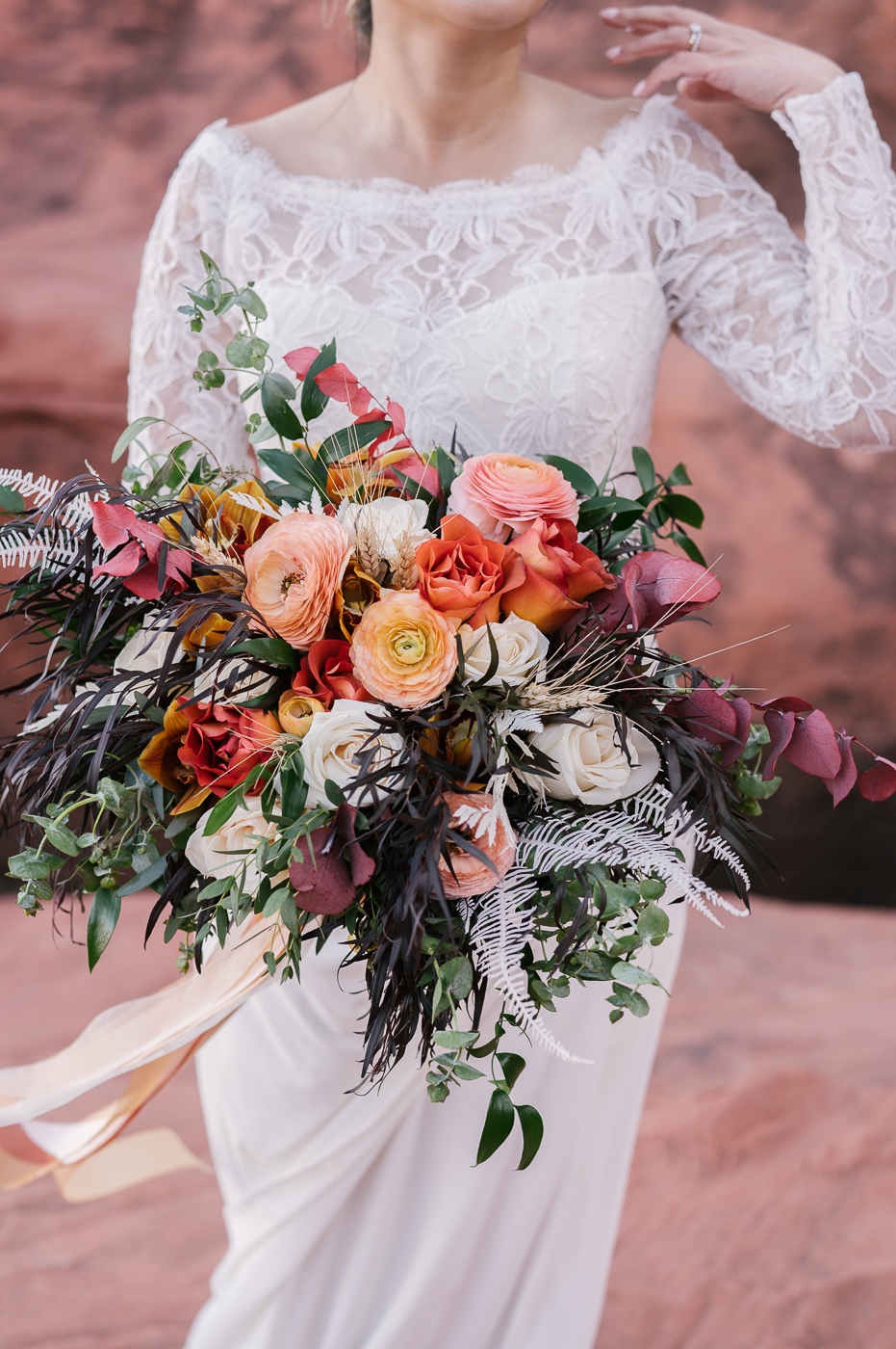 Wedding Bouquet of roses, greenery and some dried flowers in beautiful colors such as a deep purple, cream, burnt orange