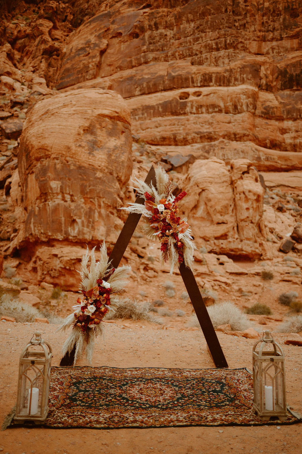 Triangle arch and boho rug with lanterns for boho Visitor Center Valley of Fire Elopement