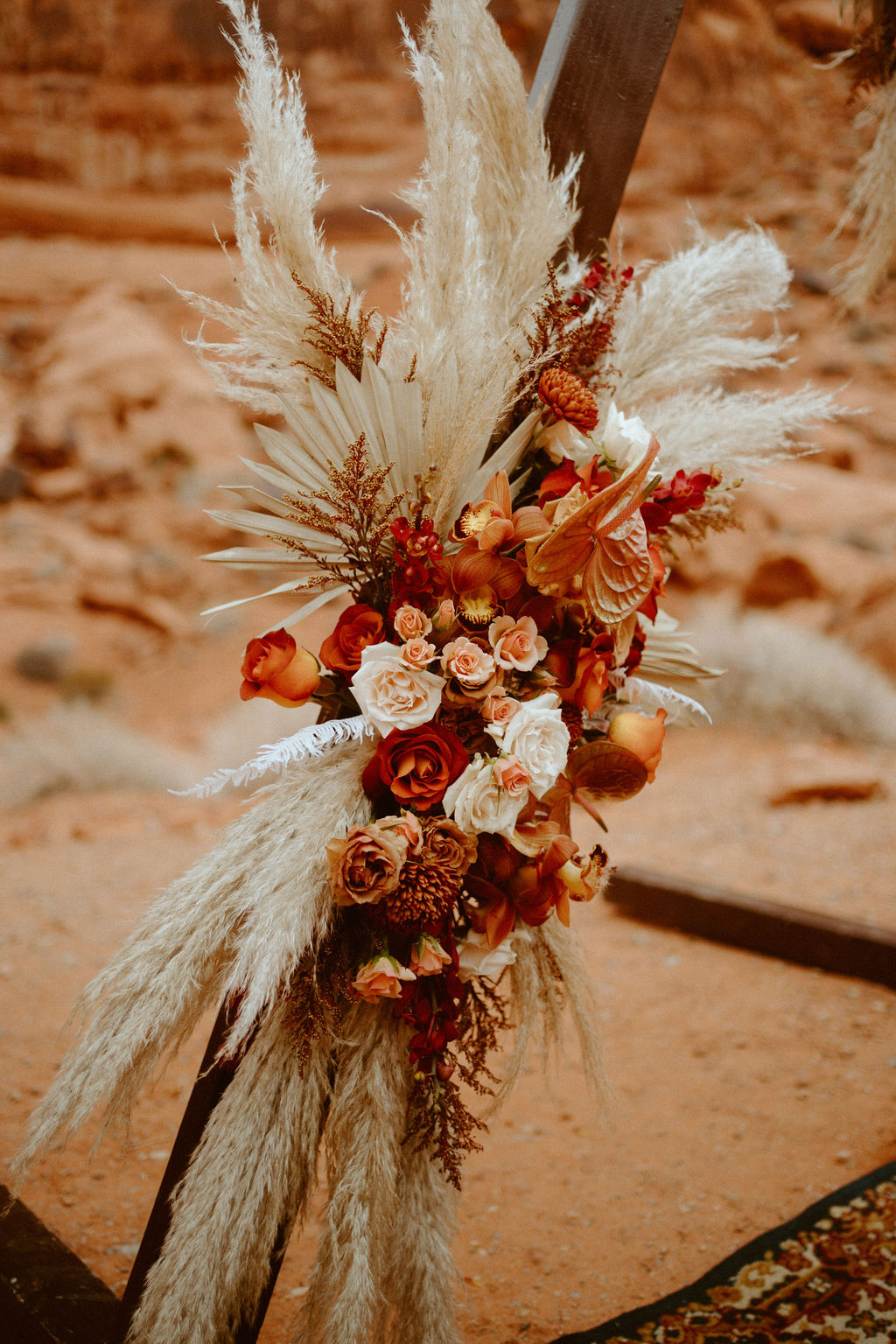 Natural triangle arch florals with pampas grass for boho chic elopement 
