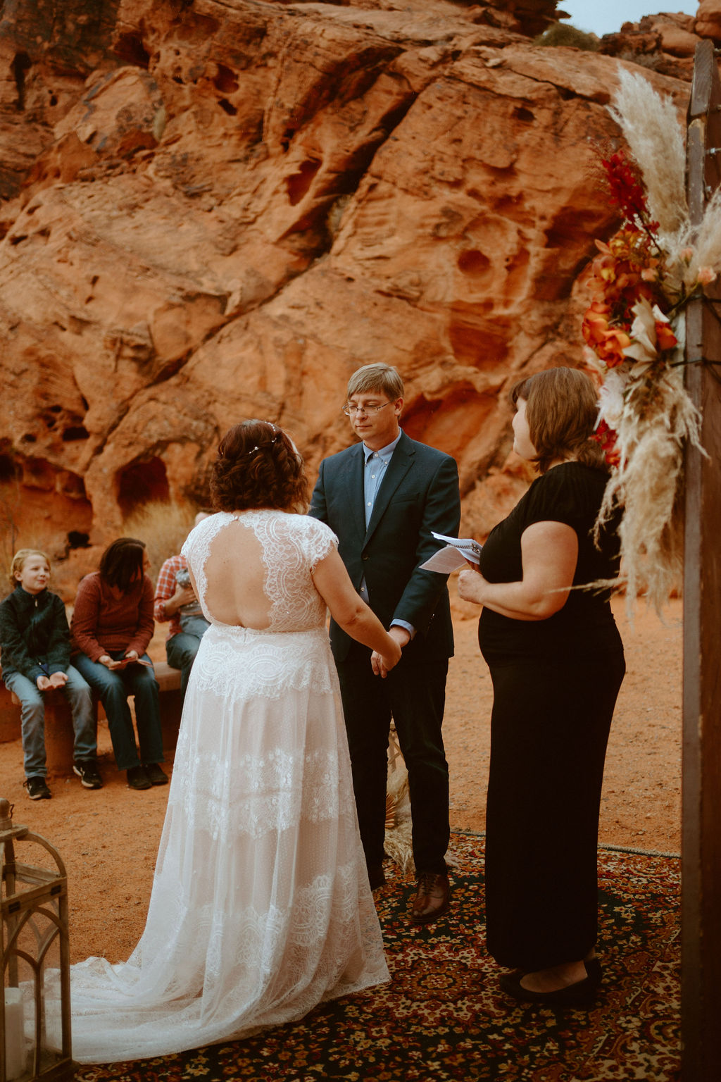 Couple Standing on Boho Rug getting Married at Visitor Center Valley of Fire Elopement