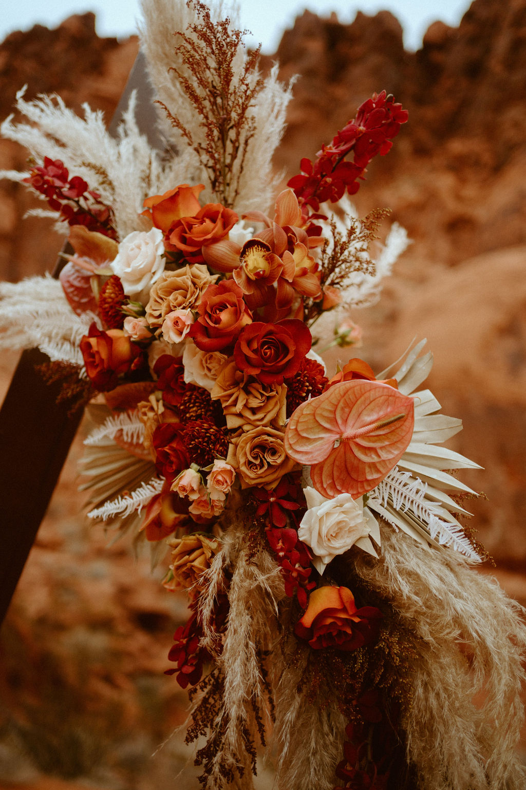 Rust and red natural triangle arch florals with pampas grass for boho chic elopement 