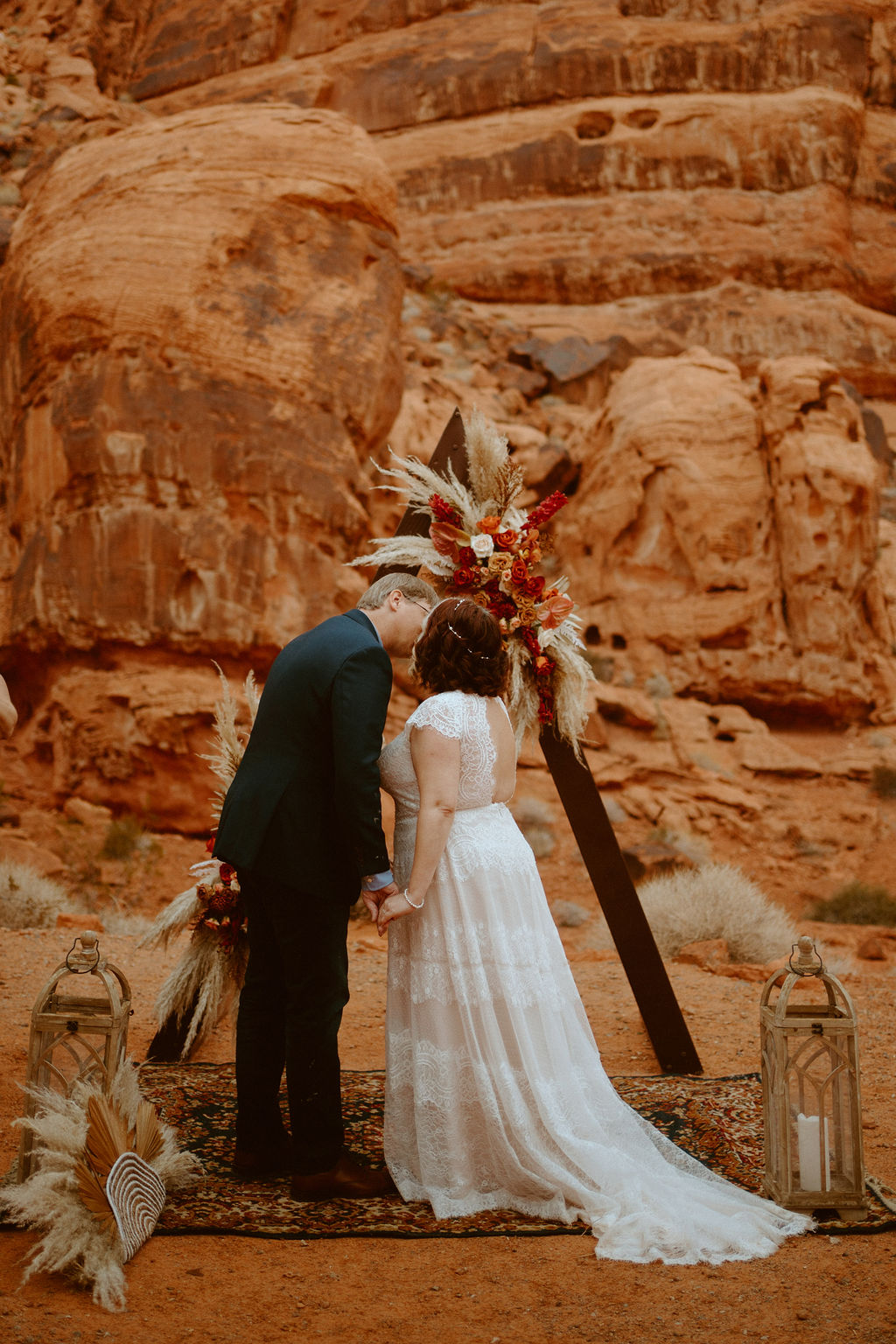 Newlyweds First Kiss under Triangle Arch in Desert Elopement
