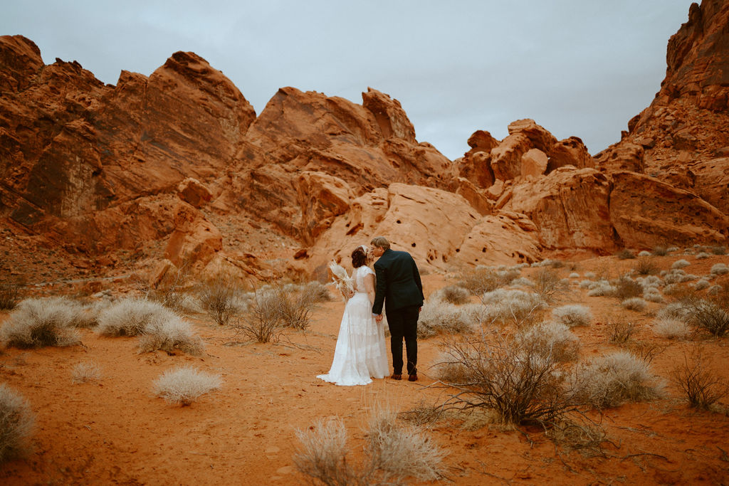 Bride and Groom Kissing in Dramatic Red Desert 