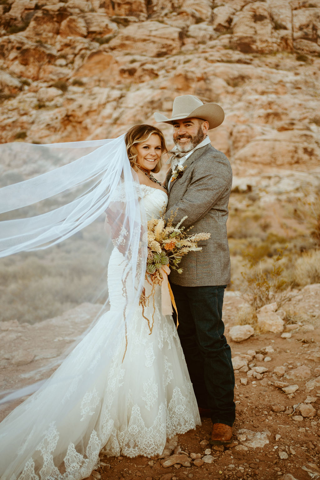 Bride with Veil and Mermaid dress with lace details with Groom in desert 