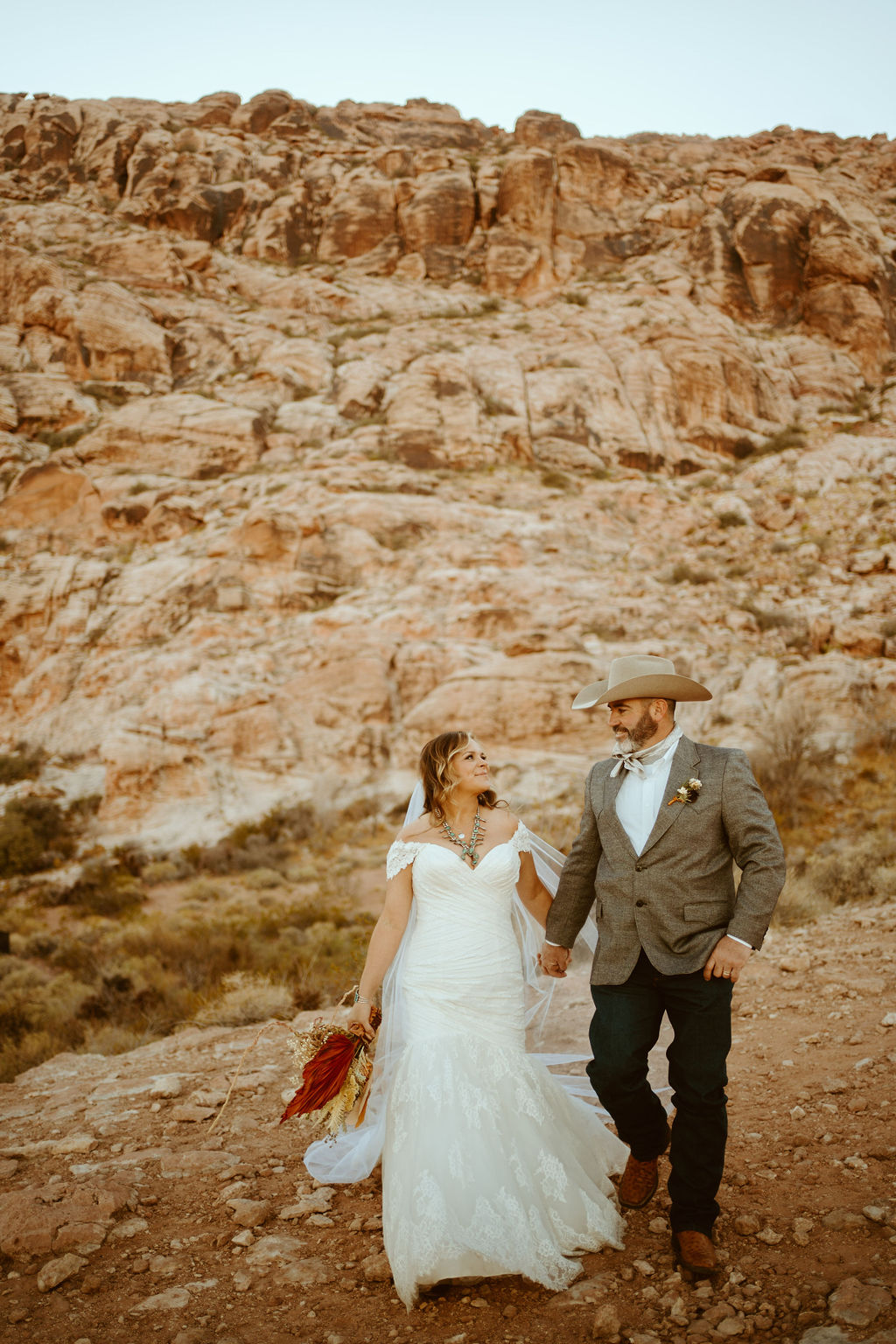 Newlyweds walking in Red Rock Canyon after Western Inspired Turquoise Boho Elopement 