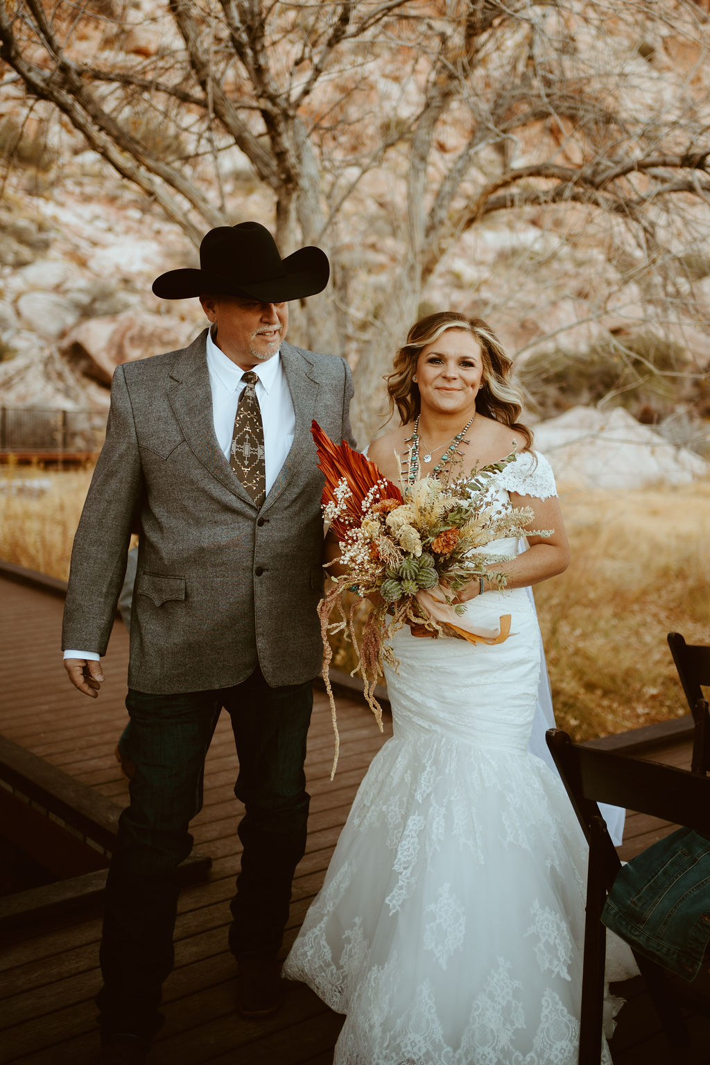 Bride with dried floral desert bouquet walking down aisle for Western Inspired Turquoise Boho Elopement 
