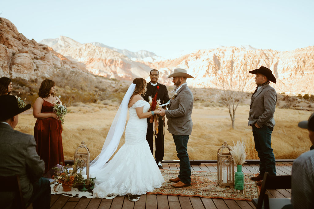 Couple getting Married at Red Rock Canyon in Western Inspired Turquoise Boho Elopement with cow hide rug and bohemian rug 