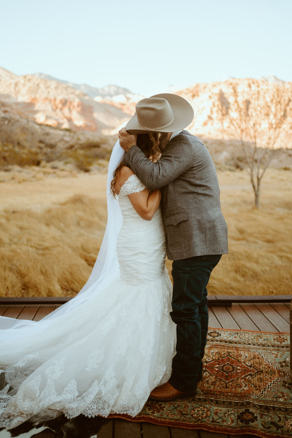 Groom taking off Cowboy hat to kiss bride for first time in Western Inspired Turquoise Boho Elopement 
