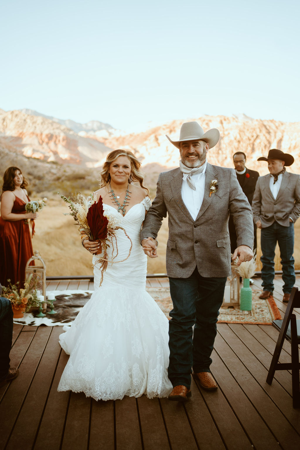 Newlyweds smiling walking down aisle after eloping in Red Rock Canyon for Western Inspired Turquoise Boho Elopement 