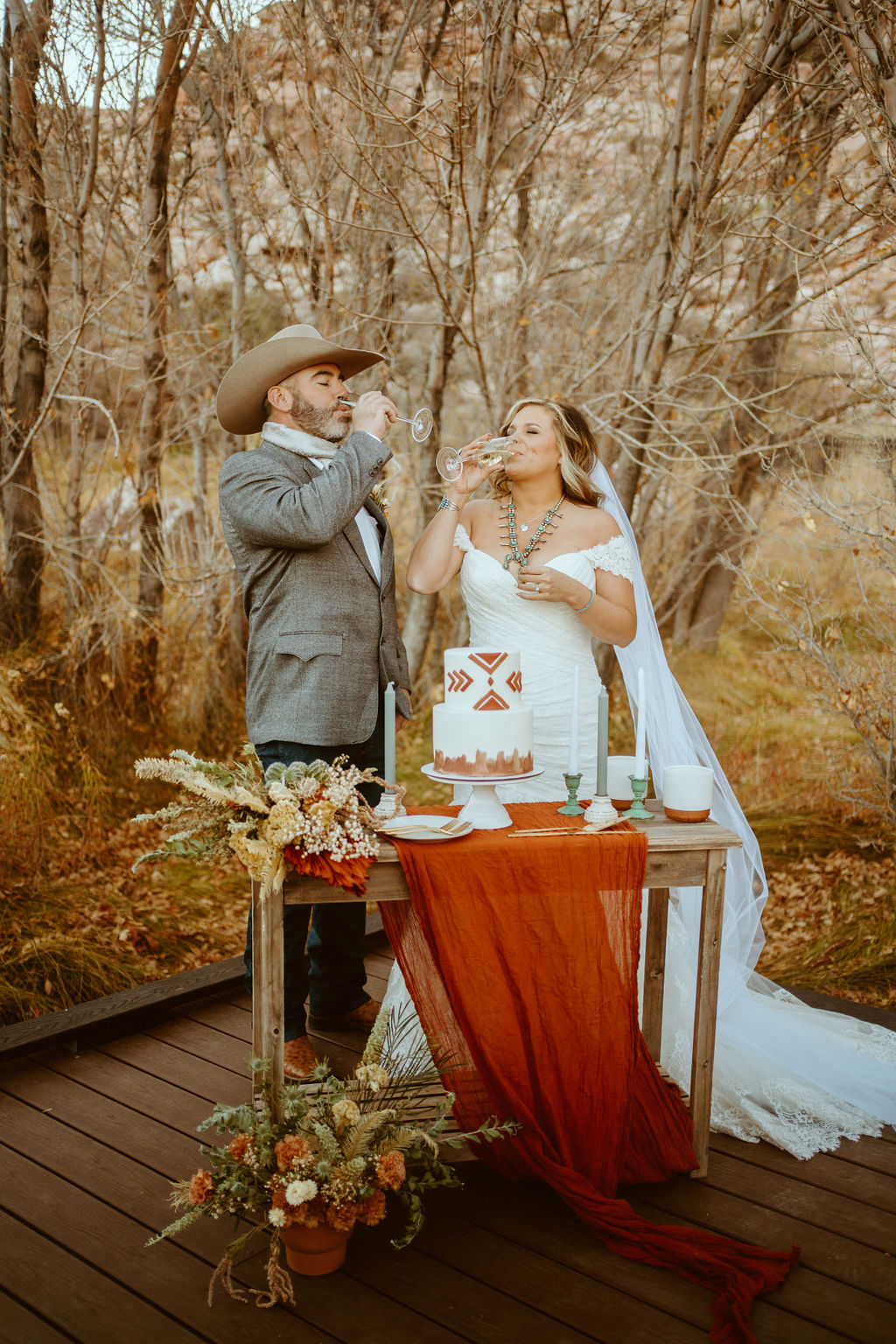 Newlyweds drinking Champagne before Cutting Caking during Western Inspired Turquoise Boho Elopement 
